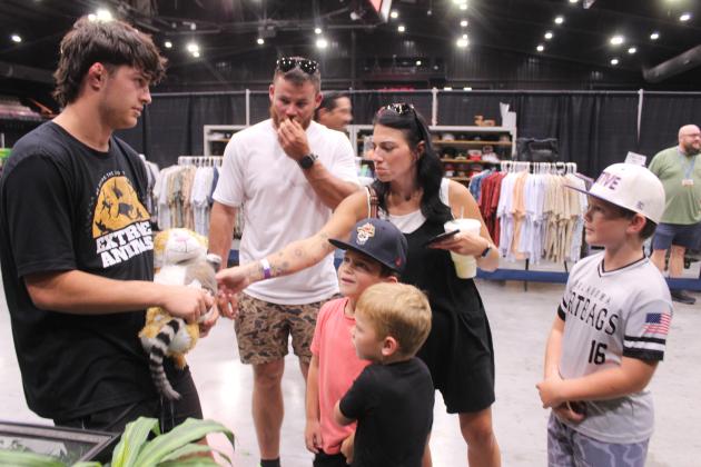 Maddox Witt holds a two-month-old Ring-tailed Lemur as the Wortman family of Ada take turns petting it at the Extreme Animals Petting Zoo during the Outdoor Nation Expo on Aug. 9. Shown, from left, are Jordon, Josie, Creed, 7, Callan, 4, and Cayston, 9, Wortman. Extreme Animals of Tuttle also brought a chinchilla, ball python, tortoises, bearded dragon, tarantula, and assorted other animals in tanks. The ONE was held at FireLake Arena in conjunction with the FireLake Fireflight Balloon Festival.