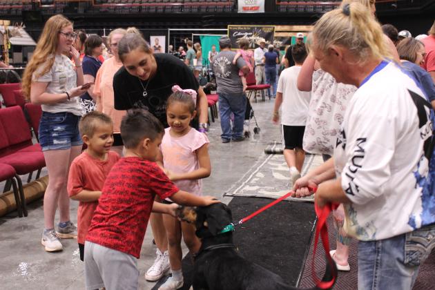 Christie Howell holds Rooster steady for three children to pet, following the Fetch n' Fish Dog Show at the Outdoor Nation Expo on Aug. 9 at FireLake Arena. This is the first year, since the ONE began in 2017, for it to be presented by the Citizen Potawatomi Nation. They also had the Youth Archery and Darkwater Adventures Target Bowfishing, as well as an assortment of vendors.