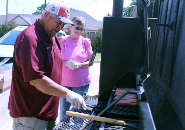 Elks Club members Andrew and Denise Iglesias grilled and wrapped about 200 hotdogs, donated by the club, during the Pack the School event for teachers to stock up on school supplies, held at First United in Shawnee on Aug. 8.