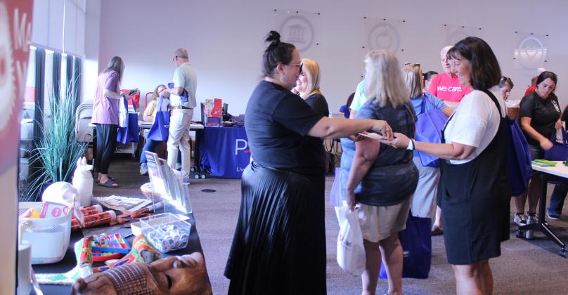 Mabee-Gerrer Museum of Art Director of Development Sylwia Partyka, left, hands out information about free school field trips during the Pack the School event for teachers to stock up on school supplies, held at First United in Shawnee on Aug. 8.