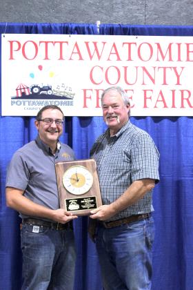 Josh Grundmann received a clock plaque from Fair Chairman Randy Gilbert in special recognition of 23 years volunteering for the Pottawatomie County Free Fair during the Awards on Sept. 6. Grundmann also began the annual Farmhand Olympics 16 years ago.