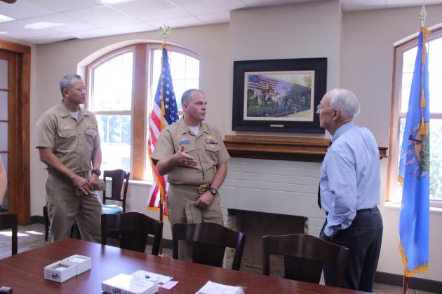 Captain Aaron Stutzman, Commanding Officer for the USS Oklahoma submarine, talks with Bill Ford with Shawnee Milling Company, as Relieving Commanding Officer CDR Jay Kim listens, during a namesake visit to the Veterans Education Museum on Sept. 9.