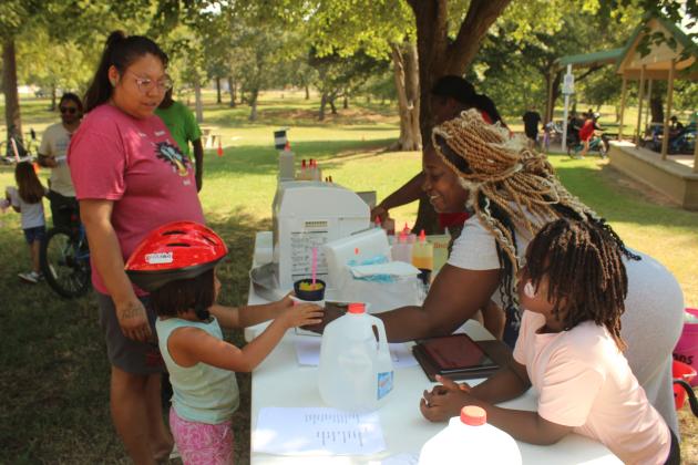Kara Lambert, with Epic Snocones, hands a snow cone to Stonie Reuben, 4, of Shawnee, as her mother, Thetath Reuben, watches during Pedalpalooza, held at Rotary Briscoe Boy Scout Park on Sept. 20. In addition to Epic Snocones, there were booths from First United Bank, VIPS, Kids Action, Pioneer Library Systems - Shawnee Library, OBU, Willier USA, Salty Dogs Cycling, Mabee-Gerrer Museum of Art, and LOL Cartoons Party Entertainment. There was also a bicycle rodeo course and about 144 free helmets from POGO.