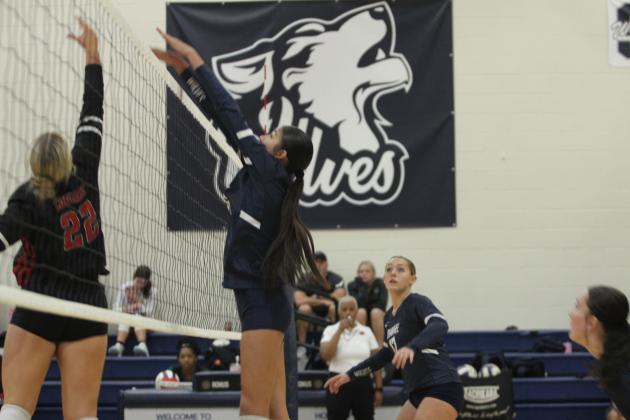 Shawnee freshman Ava Plumley jumps to block as North Rock Creek's Lauren Rowell keeps it in play during the Shawnee Volleyball Invitational Silver Bracket game, held at Shawnee Middle School on Sept. 20. The Gold Bracket games were played at Shawnee High School. The Lady Wolves won two games and lost three during the two-day tournament. Eight teams, including Tecumseh, participated.