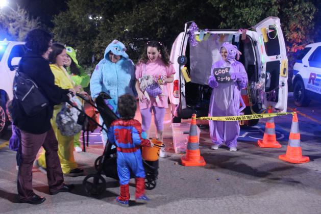 Shawnee Dispatchers Macyn Kinkade, Bianca Torrez, Shinead Promnitz and Chrissy Brown admire trick-or-treaters while handing out candy during the Second Annual First Responders Trunk or Treat, held in the FireLake Arena parking lot on the evening of Oct. 25.