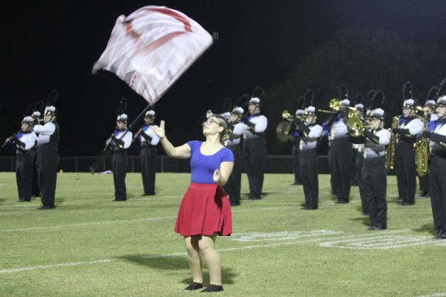 Bethel Color Guard member McKenzie Mitchell tosses her flag while performing with the Pride of Bethel Marching Band during the home game on Sept. 26.