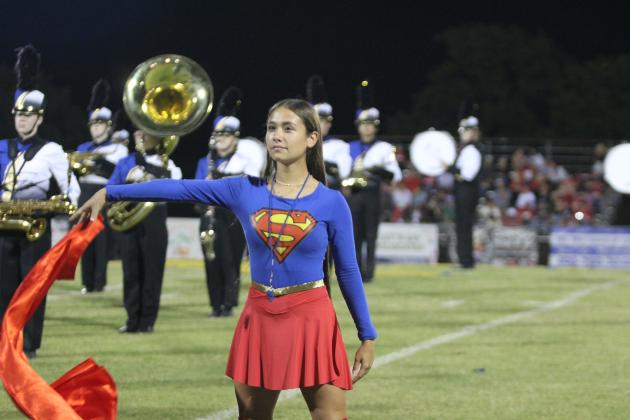 Bethel Drum Major Stohri Reynalds removes her cape and drops it before saluting, her signal that the Pride of Bethel Marching Band is ready to perform their Superman-themed music during halftime of the home game on Sept. 26.