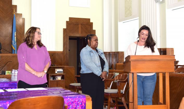 KC Campbell reads her nomination letter for Raegan Green (middle) who was honored as Advocate of the Year for Pottawatomie County  while Rene Clemmons (left) looks on at the annual Domestic Violence Awareness &amp; Awards Ceremony on Oct. 24.