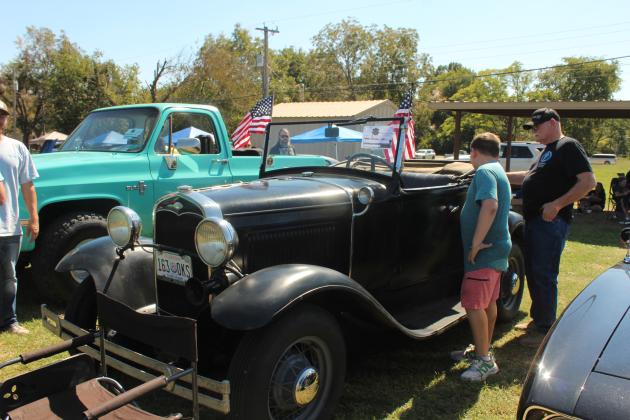 Canaan Abel, 11, of Seminole, and his friend Larry Buttram of Tecumseh look over a 1931 Model A Roadster, owned by Richard Neal Carter, in the Frontier Days Car Show on Sept. 27. The car show was held in the empty lot east of Tecumseh First Assembly of God.