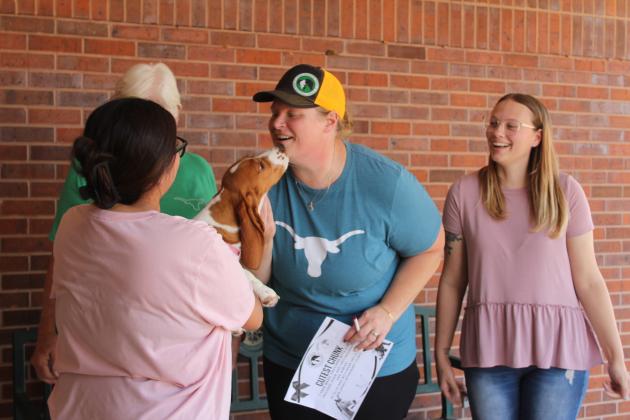 Georgia, the Bassett Hound, gives kisses to Frontier Days Pet Show judge Katie Snyder Jones, DVM. Georgia is held by her owner Maliyah Cassanova of Shawnee and received second place for Cutest Chunk.