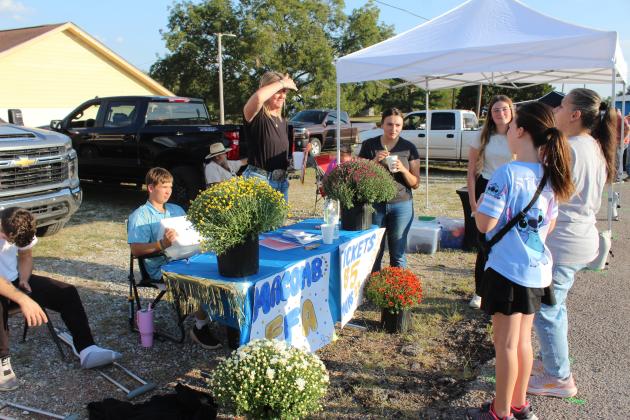 Macomb FFA Advisor Tanna Southerland talks with a woman at the FFA booth during Macomb Trade Days on Sept. 25. They were selling potted mums, as well as tickets to win Blue and Gold meat. The drawing was held that evening, but Southerland said they started with 50 potted mums and will sell them until they run out. If interested, please email her at tanna.southerland@macomb.k12.ok.us. Natasha Dunagan, Countywide &amp; Sun