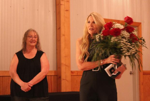 County Commissioner Melissa Dennis speaks after receiving a bouquet and lapel pin as the winner of the Pottawatomie Power Poll during the awards banquet at Crossing Hearts Ranch on Oct. 24. Also shown is Suzie Campbell, Pottawatomie Power Gala organizer and owner of the Countywide &amp; Sun newspaper. Natasha Dunagan, Countywide &amp; Sun