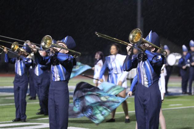 The Shawnee High School Pride of the Pack Marching Band and Color Guard perform in the rain during halftime of the Oct. 23 homecoming game. Their theme for this year is "Origins of Medusa." After their performance, the game was called due to lightning in the area.