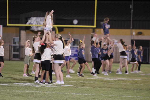 The older two groups of Tecumseh's Savage Cheer Clinic participants form pyramids during halftime of the Oct. 16 home game.