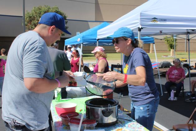 Cindy Stober offers her "Super Sober" chili to Chris Geddes, with the Evangelistic Center, during the Second Annual Worrell's Haven Chili Cook Off, held in the Shawnee High School parking lot on Oct. 4. The event had an "OU versus OSU" tailgating theme, and attendees could vote on 18 types of chili. The Evangelistic Center was one of 19 sponsors. This is one of two annual fundraisers for the women's recovery house. Next, they will have Glow-in-the-Dark Bingo in April.
