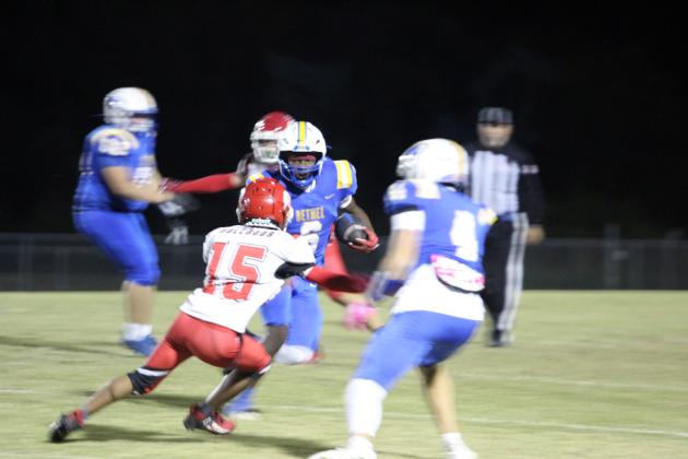 Bethel senior Ezra Powis dodges the Okmulgee defense as he carries the ball for a first down and 10 during the first quarter of the Oct. 31 homecoming game. This was one play before Powis made a touchdown.