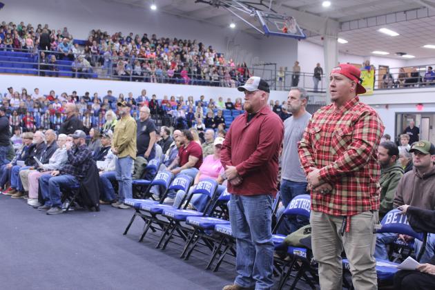 U.S. Marine Corp veterans stand for their military branch theme song during the Veterans Day Program at Bethel High School on Nov. 11.