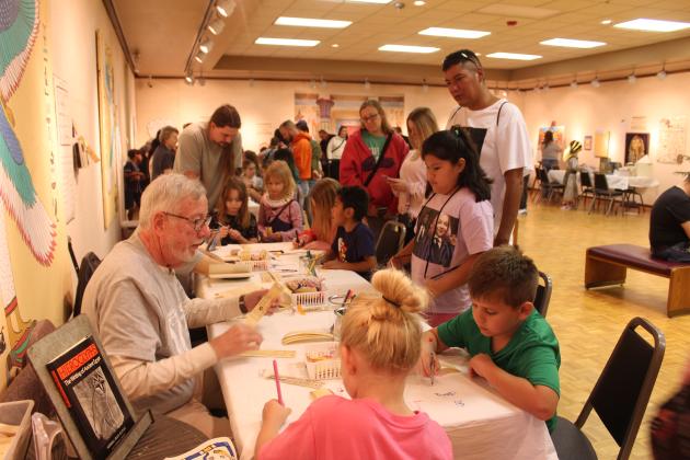 Volunteer John Blum instructs children in writing hierolglyphics on papyrus bookmarks during the Fifth Annual Mummy Day, Nov. 8. There were about 917 visitors to the museum that day, according to Director of Development Sylwia Partyka, where they could make crafts like these or learn about ancient Egypt.