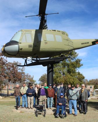 All of the veterans in attendance at the Veterans Day Program, hosted by the Shawnee Veterans Memorial Committee, pose under the newly-painted 1965 Huey helicopter. A volunteer came from Texas to paint it, said emcee Marine veteran and VFW Post 1317 Commander Patrick Koch. Natasha Dunagan, Countywide &amp; Sun