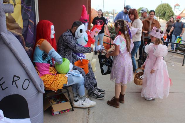 Dressed as characters from "The Nightmare Before Christmas," Maggie and Brian Grinnell with Clarity MMA hand out candy to a fairy and a princess during the Tecumseh Business Treat 'r Treat on Oct. 31.