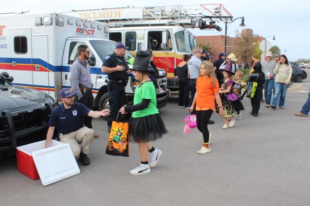Tecumseh Police Officer Zach Steingas handed out candy from a cooler at the corner of Broadway and Washington for the Tecumseh Business Treat 'r Treat on Oct. 31. Also shown are Lt. Dakota Snow, Officer Austin Parks, Firefighter Kate Haratsis and Paramedic John Oxford.