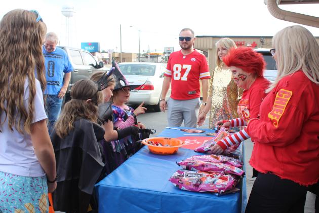 Arvest employees Tyler Wilburn, Jacki Robb, Kim Rawls and Regene Kennedy set up their candy table in front of Gilbert's Insurance and Tecumseh Tag Agency for the Tecumseh Business Treat 'r Treat on Oct. 31.