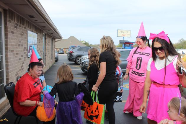 Suzanne Gilbert and Leda Canada hand out candy in front of Gilbert Insurance and Tecumseh Tag Agency for the Tecumseh Business Treat 'r Treat on Oct. 31. Everyone in their office dressed as Crayons that day.