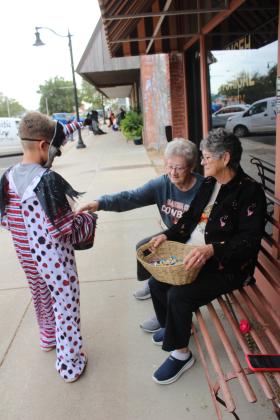 Tecumseh History Museum volunteers and Alumni leaders Jane Fleming and Jan Parker give candy to a clown during the Tecumseh Business Treat 'r Treat on Oct. 31. Parker said they handed out at least 1,100 pieces of candy between 3 and 5 pm.