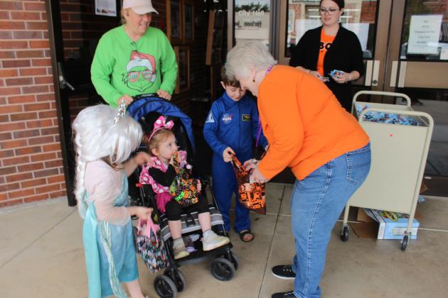 Tecumseh librarians Jerilyn Hart and Caitlin Love give away fruit gummies and candy in front of City Hall during the Tecumseh Business Treat 'r Treat on Oct. 31.
