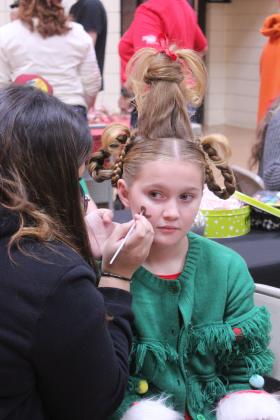 Eliyah McEwin, 9, of Tecumseh, has a gingerbread man painted on her face during the Whoville event in the Tecumseh City Hall Auditorium on Dec. 11. McEwin's mother, who was volunteering at the Experience Church booth, said her daughter looks forward to dressing up like Cindy Lou Who for Grinchmas/Whoville every year. Tecumseh Chamber of Commerce Executive Director Kim Elliott estimates that 1500 people visited Whoville.