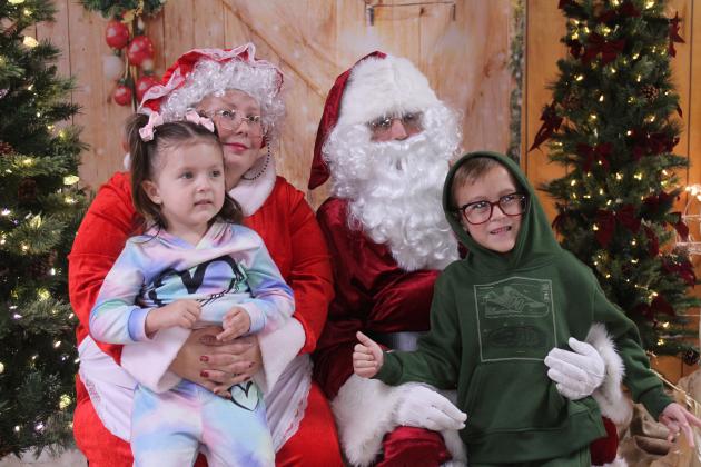Lexa, 3, and Ezra Ratigan, 4, both of Shawnee, pose with Mrs. Claus and Santa Claus during the First Annual Grinch-fast, held at the Veterans of Foreign Wars in Shawnee on Nov. 29. This was a fundraiser for the Pottawatomie County Giving Project, which has 618 children and adults with disabilities on their Christmas list this year.