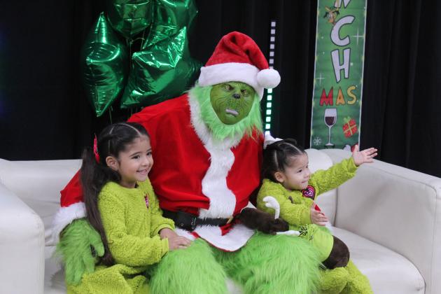 Sophia Villegas, 4, and Azul Villegas, 1, both of Shawnee, sit with the Grinch in the City of Tecumseh Chambers during the Grinchmas/Whoville event on Dec. 11. (Azul was motioning for her mother to pick her back up.) Tecumseh Public Library/Pioneer Library System staff took and printed pictures with the Grinch, as they have in past years.
