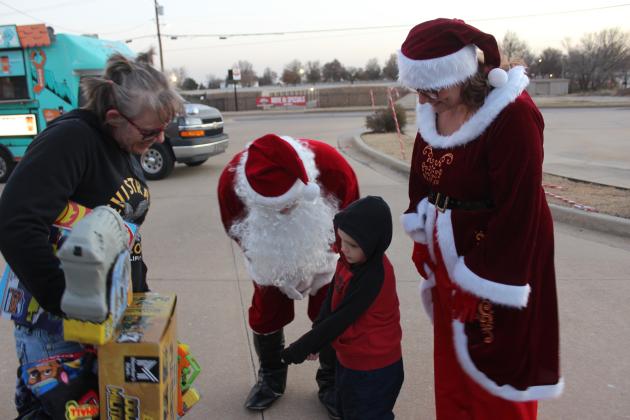 Santa Claus lends an ear to Cannon Winsett, 5, as Mrs. Claus and Katrina Reins watch during the Fourth Annual Shawnee Police Department Toy Drive on Dec. 18. Public Information Officer Corporal Vivian Lozano-Stafford said they had 200 children who registered online.