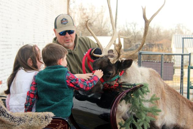 Charlie Burton, 6, and Hunter Knoch, 3, both of Midwest City, pet Rose the Reindeer as her handler, Nick Ledbetter, supervises at The McLoud Mercantile on Dec. 20. Rose comes from the Reindeer Club in Bristow, and Mercantile co-owner Samantha Sessums said in a video on their Facebook page that she has been trying for three years to get the live reindeer there.