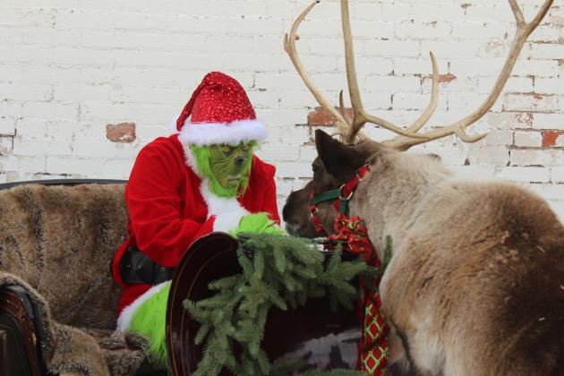 The Grinch has a silent stare-down with Rose the Reindeer during the Christmas event at The McLoud Mercantile on Dec. 20.