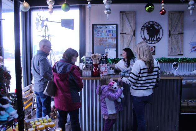 Okie Dokie Mercantile Owner Christina Hernandez finishes checking out a family at her ninth anniversary event in Shawnee on Nov. 28.