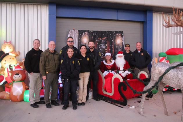 Capt. Stafford, Deputy Chief Goss, Ofc. Kelli Cotton, Cpl. Vivian Lozano-Stafford, Chief Wilson, Ofc. Conley, Cpl. Soward and Cpl. Nichols pose with Mrs. Claus and Santa Claus at the Fourth Annual Shawnee Police Department Toy Drive on Dec. 18.