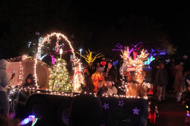 Members of Girl Scout Troop 240 ride on their float, which featured a "campfire," tree, snowman and reindeer, in the Shawnee Parade of Lights along Main Street on Dec. 12. According to State Representative Dell Kerbs, with Safe Events for Families, there were 117 entries in the two-hour parade.