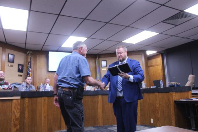 Shawnee Superintendent Jason James, right, shakes hands with Director of Maintenance Bill Huskey, as he announces Huskey's retirement during the Dec. 15 Shawnee Board of Education meeting. James also presented Huskey with a commemorative clock.