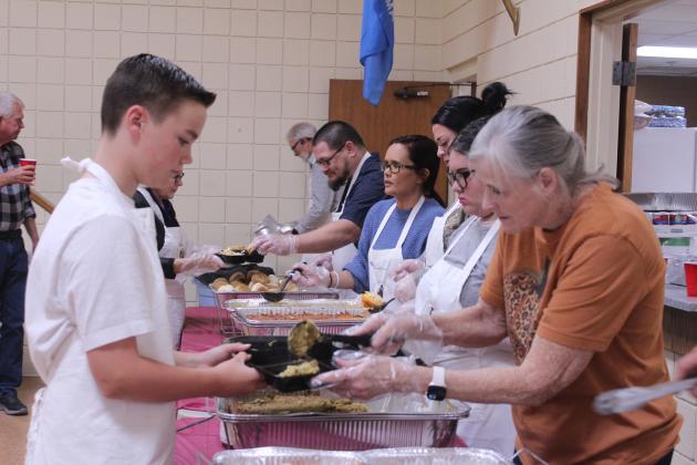 Volunteer Rita Goodson, right, scoops dressing onto a plate held by Legend Baker for him to deliver to guests during the 20th Anniversary Tecumseh Family Thanksgiving Dinner, held at Tecumseh City Hall Auditorium on Nov. 27. Baker is the grandson of Randy and Suzanne Gilbert, who started the event. S. Gilbert said they served nearly 1,250 dinners - both in person and to-go - this year.
