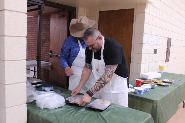 Tecumseh Police Chief J.R. Kidney and former OKC police officer John Blumenthal prepare to-go meals during the 20th Anniversary Tecumseh Family Thanksgiving Dinner, held at the Tecumseh City Hall Auditorium on Nov. 27. Blumenthal volunteered with his mother, Louise Blumenthal.
