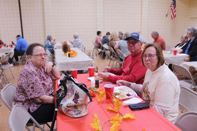 Gerald and Gina Rounsaville pause their dinner to pose with long-time friend Mary Ellen Lam during the 20th Anniversary Tecumseh Family Thanksgiving Dinner, held at the Tecumseh City Hall Auditorium on Nov. 27. The Rounsavilles have volunteered at the event for all 20 years.