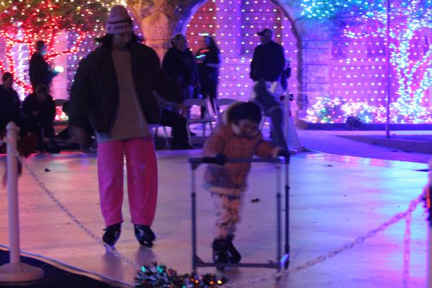 Lexi McAlister watches over Octavia McIntyre, 4, both of Shawnee, as they make their way around the ice skating rink made of synthetic ice, lit by the Christmas lights decorating the Santa Fe Depot in Shawnee, during the Safe Events for Families "Winter Wonderland" on Nov. 28.
