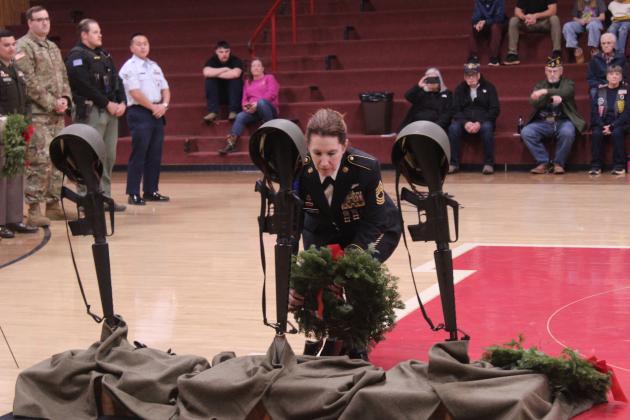 Retired Master Sergeant Rebecca McGary places a wreath for the United States Space Force during the Wreaths Across America Ceremony, held at Macomb High School gymnasium on Dec. 13. Veterans, Sheriff's deputies, and Gold Star father David Hendrickson also placed wreaths for the military branches, POW-MIA and Gold Star Families.