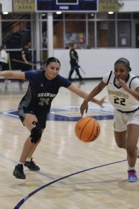 Shawnee senior Daley Rice and a Midwest City player scramble for a loose ball in the Jan. 22 game against Midwest City during the Shawnee Invitational. The Lady Wolves lost this hard-fought game 50-54. The day before, they won with Harding Charter 55-19.