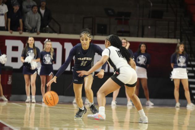 Shawnee senior Tarilyn Thierry dribbles around the Del City defense during the Class 5A State Quarterfinal game against Del City, held at the Lloyd Noble Center in Norman on March 12. The Lady Wolves lost, 34-44, and ended their season with a record of 21-7.  Click on the camera below to see all of the photos from the game!