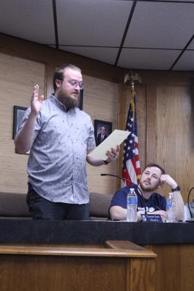 During the March 9 meeting, Shawnee Board of Education member Turner Bass swears himself in after being re-elected to the Ward 6 seat. Also shown is fellow board member Casey White.