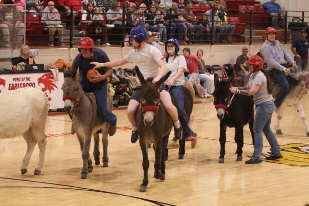 John Cole, with the Booking Broncos, tries to steal the ball from Caleb Inman, with the Code 3 Kickers, during the Third Annual Earlsboro Donkey Basketball fundraiser on April 4 at the EHS Gym. Sponsored by the Earlsboro Fire Department and Police Department, the event raised $5,801 this year, which goes toward things like vehicle maintenance, fuel, equipment upgrades and firefighter gear, according to Police Chief Christopher Bayless and Firefighter Beau Dailey.