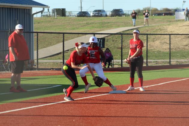Earlsboro freshman Zory McGregor steps on third base on her way to a home run, as Macomb pitcher Rylee Hancock tries for the tag and Deja Givens looks on, during the April 2 game played at the BCM Sports Complex in Seminole. Also shown, far left, is Earlsboro Slow Pitch Head Coach Keith Gunter. The Lady Wildcats beat the Lady Hornets in overtime, 8-7.