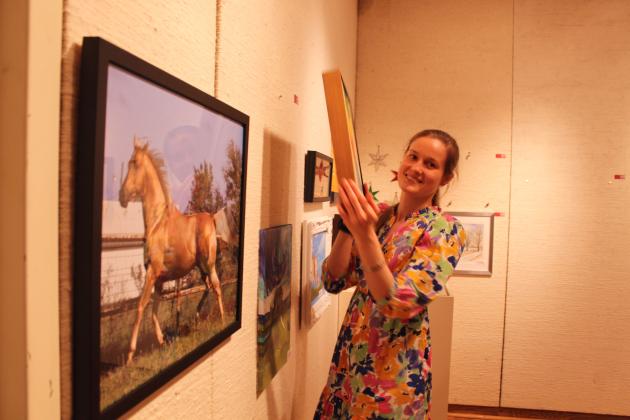 Taylor Casper picks an artpiece by Steve Hicks at the annual "Off the Wall" event at the Mabee-Gerrer Museum of Art on April 24.